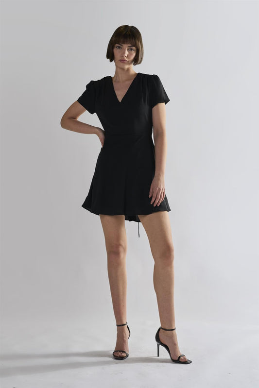 black V-neck mini-dress with short sleeves and a tie waist, paired with high heels By Glamorous